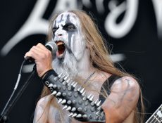 Angry-looking musician holding a mike on a stage