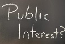 Blackboard with the words "Public Interest?" written on it